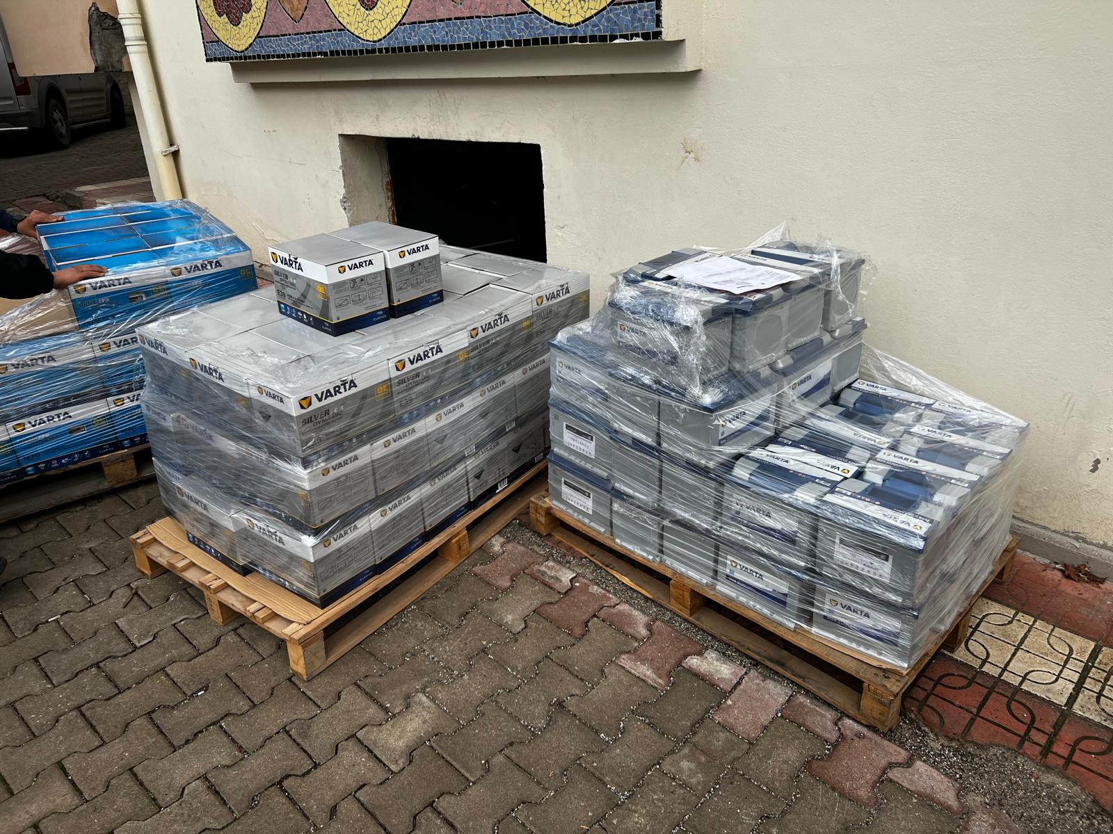 Tuğla zeminli açık alanda streç filmli akü paletleri